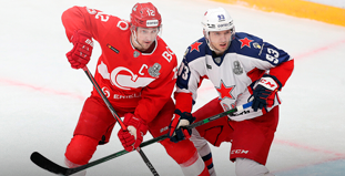 Два хоккеиста в красной и белой форме с клюшками борются за шайбу на льду