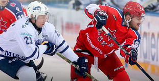 Два хоккеиста в борьбе за шайбу на льду: в белой форме 21 и в красной с логотипом звезды